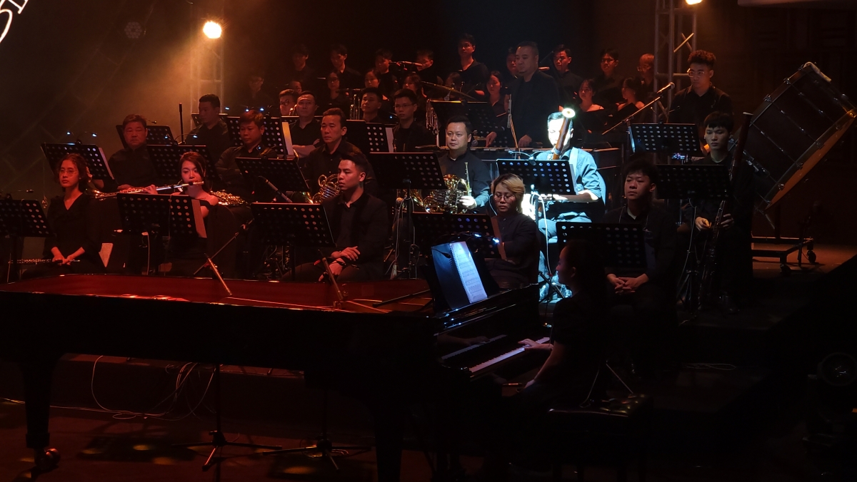 Các nghệ sĩ chơi đàn piano và các nhạc cụ hơi trên sân khấu.